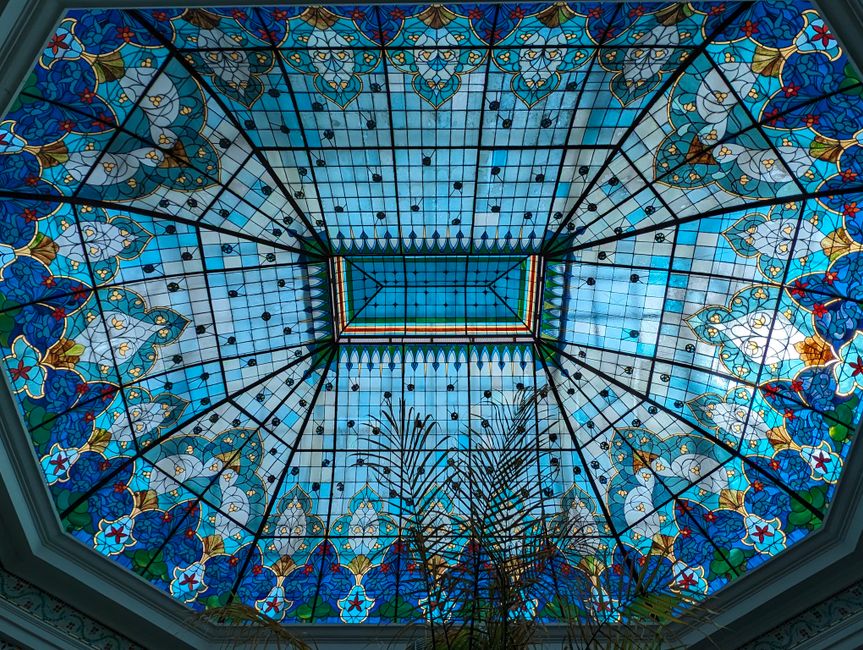 Kleurrijk glas schilderij naast badkuip.